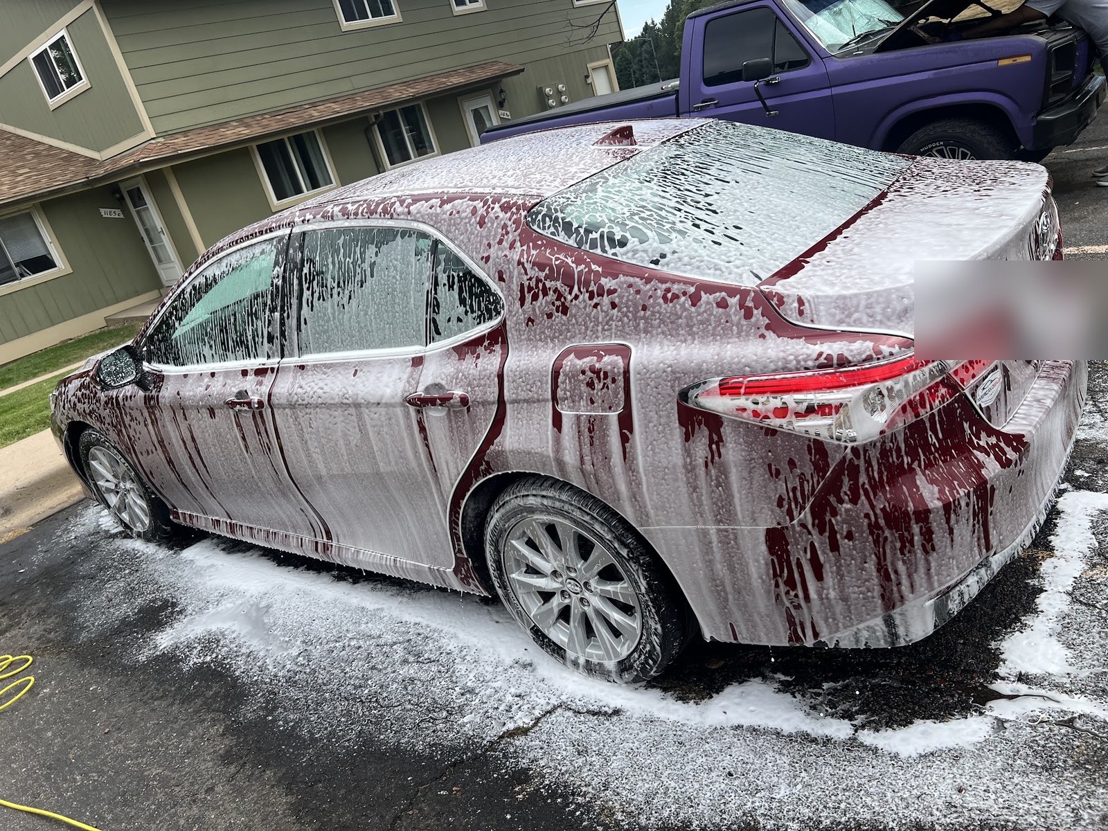 A sedan covered in wash suds mid hand-wash by RedOne Auto Mobile Detailing