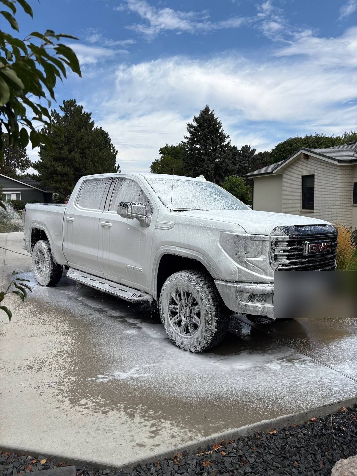 A pickup truck covered in wash suds during an exterior hand wash